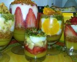 A picture of step 14 of Kunafa and Qashtalia Decorated with Oranges, Strawberries, and Bananas.