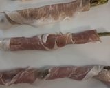 A picture of step 2 of Asparagus wrapped in prosciutto ham.