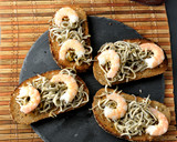 Foto del paso 4 de la receta: Tostas de pan de centeno con gulas y langostinos