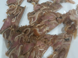 Oreja de cerdo sobre brava y cebollita japonesa