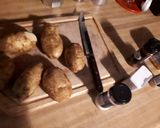 A picture of step 1 of Wedged potato jackets served with veges.