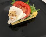 A picture of step 4 of Savory Polenta Tart with Pesto, Ricotta, Arugula, Tomatoes, Mozzarella, and Walnuts.