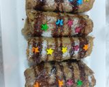 A picture of step 4 of Banana cinnamon bread rolls with chocolate syrup garnish.