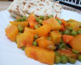 A picture of step 5 of Sweet Potato Curry and peas served with naan bread.