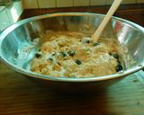 A picture of step 5 of COCONUT MUFFINS with blue berries and chocolate chips.