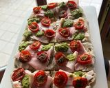 Foto del passaggio 7 della ricetta Pinsa gourmet pomodorini caramellati, prosciutto cotto e pesto
