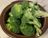 A picture of step 2 of Fried rice topped with green veggies.