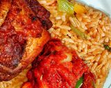 A picture of step 10 of Ghanaian vegetable Jollof rice with red seasoned chicken.