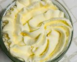 A picture of step 3 of Milk jelly pudding topped with sweetened whipped cream.