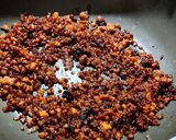 A picture of step 1 of Wheat flour seeds and nuts Ladoo with leftover ghee residue.