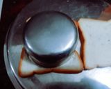 A picture of step 1 of Halloween spooky bread sandwich with tomato sauce.