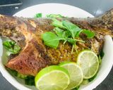 A picture of step 11 of Baked Tilapia Fish served with rocket leaves.