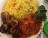 A picture of step 5 of Fried rice n plantain with chicken sauce garnished with kale leaf.