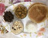 A picture of step 5 of Puri, sooji halwa, white and black chana with rice.