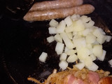 Salchicha de cerdo con patata, tomates cherry y bocadillo de queso
