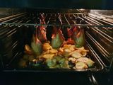 Курячі гомілки на решітці з картоплею в деко