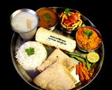 A picture of step 4 of Kathiyawadi Lunch Thali (Dahi Tikhari, Sev Tameta Nu Shak, Dal Bhaat, Fulka Rotli, Chaas, Papad).