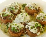 A picture of step 3 of Hummus stuffed cheesy mushrooms.