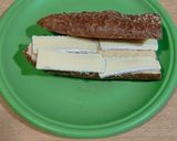 A picture of step 1 of Sandwich with 7-Grain Bread, Brie Cheese, Roasted Red Pepper Strips, and Hummus.