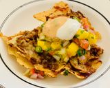 A picture of step 11 of Loaded Nachos with Mango Salsa, Sour cream and cheese sauce.