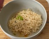 A picture of step 5 of Jah Jan Mien (instant packet noodles) with peanut butter, spring onions topped with fried egg.