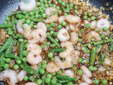Merluza en salsa, con trigueros guisantes y gambitas