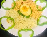 A picture of step 3 of Chicken schezwan Maggi noodles and tossed boiled egg with Maggi seasoning.